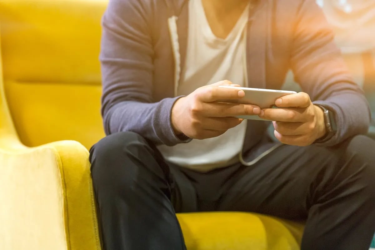 A man using his cell phone on a couch