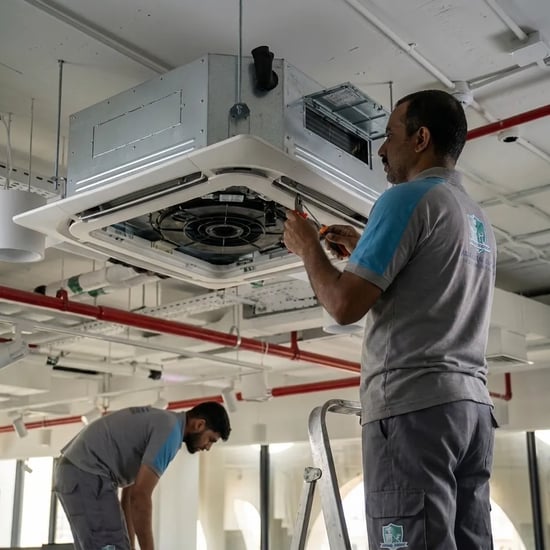 FAJ technician servicing a commercial cassette air conditioner in Dubai