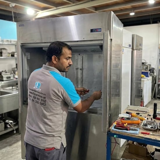 FAJ technician repairing a commercial refrigeration cabinet in Dubai