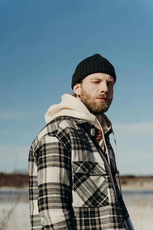 a portrait of a person transformed into a DC Comics–style comic illustration with sharp ink outlines, angular facial features, dramatic shadow blocks, saturated colors, and a serious superhero tone