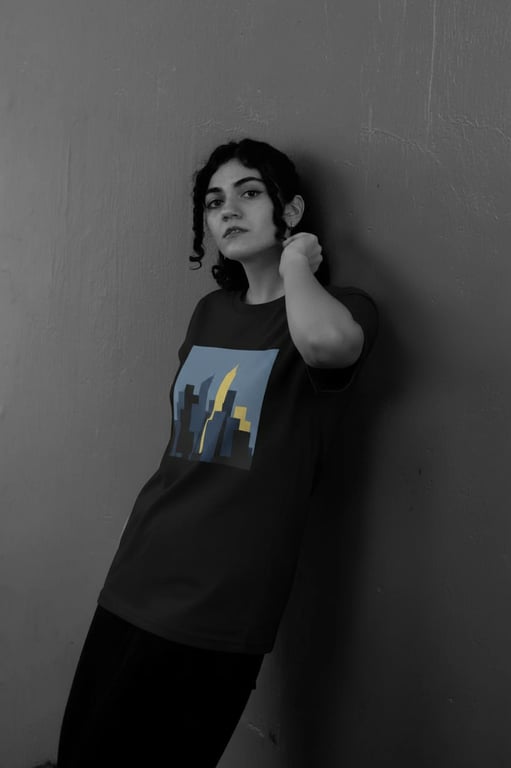 a portrait of a person transformed with a refined T-shirt design presentation featuring a single flat illustration placed inside a rectangular print area on the chest, limited color palette, no texture or pattern fill, clean borders, accurate fabric interaction, consistent lighting, and natural body posture