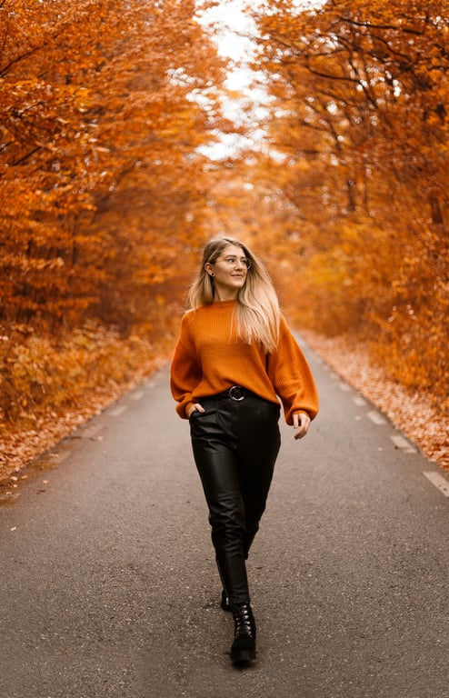 Autumn tunnel of orange foliage framing a relaxed walk in soft daylight.