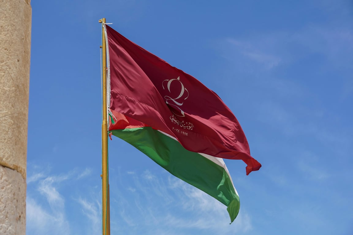 A tricolor vertical triband flag with geometric symbols, colors representing earth (green), peace (white), and knowledge (blue), a central stylized sun emblem, simple and bold.