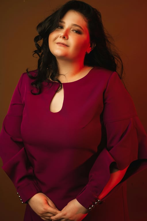 a portrait of a person photographed at eye level in a head-and-shoulders crop, front-facing or slight three-quarter angle; strongly reduce the appearance of a double chin by visibly compressing and tightening the under-chin area, clearly reshaping the jaw-to-neck separation so the chin appears slimmer and more lifted; preserve original facial identity and bone structure; maintain natural skin texture and pores; avoid plastic blur or warping; do not modify or replace the background; the slimming effect must be clearly noticeable at first glance