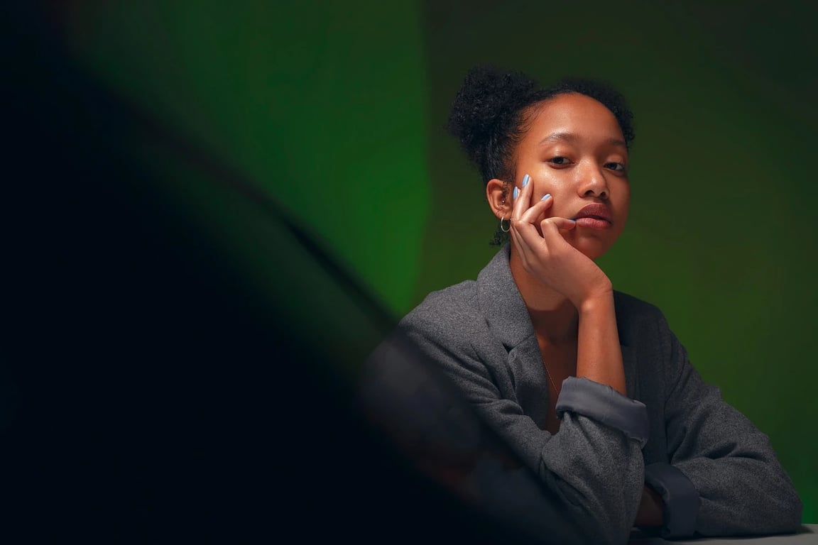 AI green screen remover before photo - woman sitting against dark green background