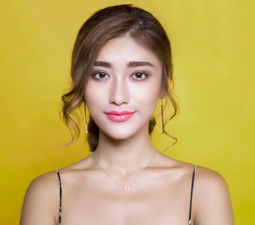 Wolf cut filter before pic – woman with mid-length brown hair smiling against yellow background