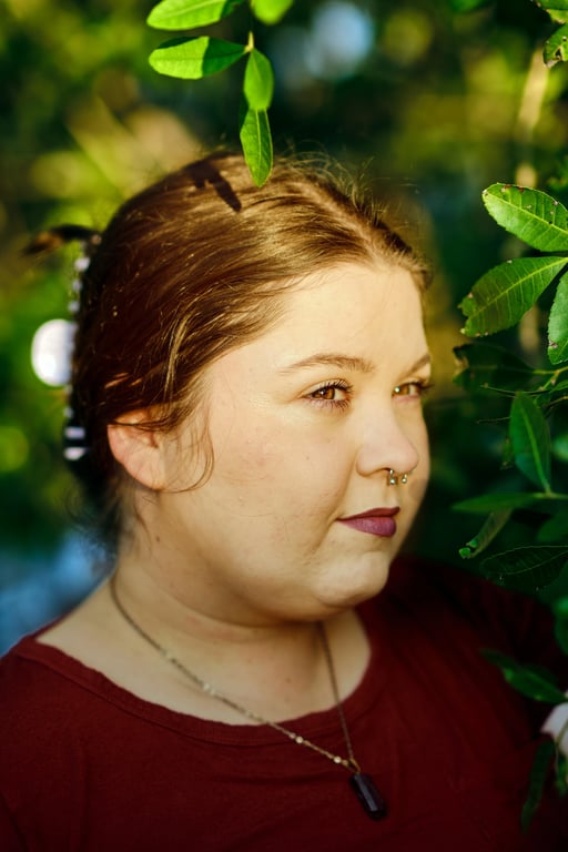 a portrait of a person enhanced to create a visibly slimmer lower face by aggressively reducing under-chin volume and reinforcing jawline separation; reshape the submental contour so the chin reads sharper and lighter; maintain original facial proportions and identity; preserve pores and skin detail; avoid over-blurring; do not alter background or scene; the improvement should be immediately noticeable without comparison