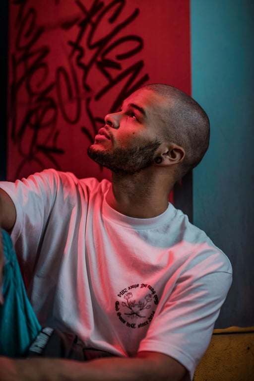 a portrait of a person with neon paint splashes or drips glowing brightly on their skin and clothes under black light