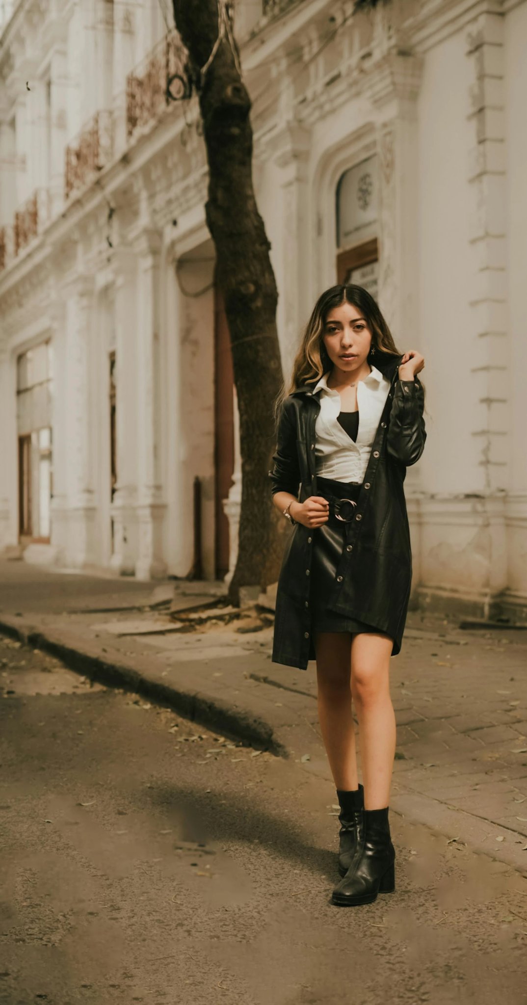 An urban street photography shot with grey buildings and asphalt.