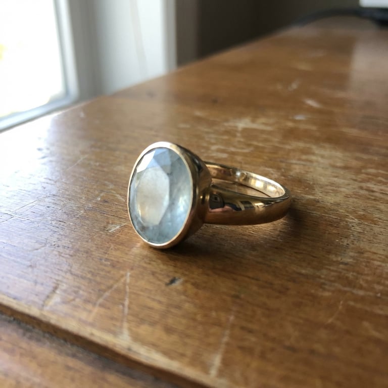 Create a close-up, brand new studio shot emphasizing the ring’s sheen, material details, and fine texture, with pristine reflections and a clean, minimalist white background