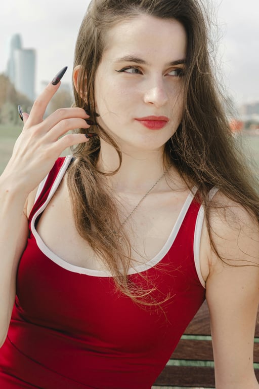 AI ugly filter before photo- woman in red top smiling against plain background