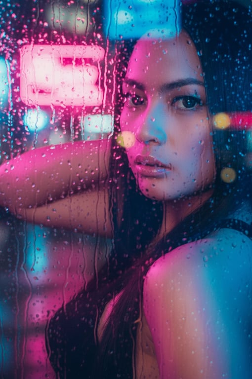 a portrait of a person with a cyberpunk neon glow filter, face illuminated by vibrant pink and blue neon signs, with rain streaks on glass