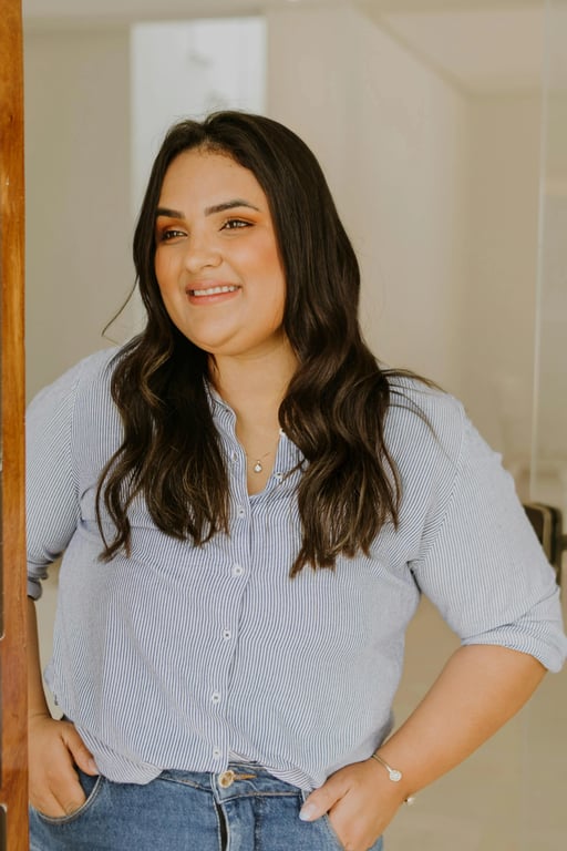 a portrait of a person with a clearly slimmer chin created by compressing under-chin fullness and smoothing excess volume while maintaining jawline geometry; reinforce a clean neckline silhouette; preserve facial identity, skin pores, and natural shading; avoid plastic skin effects; do not modify background; the face should read noticeably leaner in the lower region