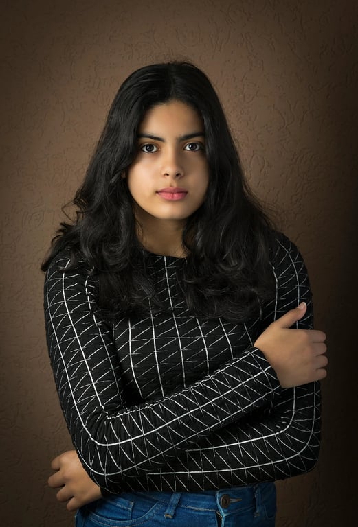 a portrait of a person wearing a minimalist structured jacket with straight pants, architectural tailoring, matte fabric, restrained styling, confident still pose, clean studio lighting
