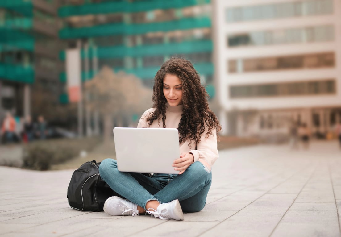 Wolf cut filter before pic – woman sitting outdoors with laptop and natural curl hair