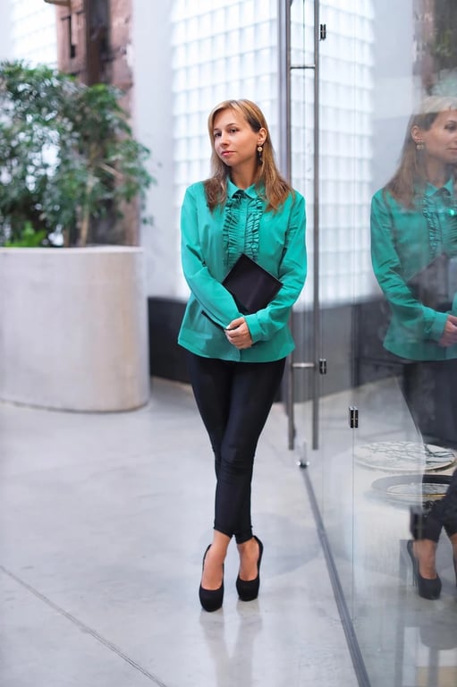 A full-body photo of a young woman standing and wearing casual jeans and a top.