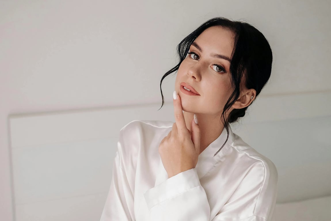 a portrait of a person edited to move the hairline forward in a clear and aggressive way, filling sparse frontal areas so the hair starts lower on the forehead and creates a thicker, more youthful hair frame