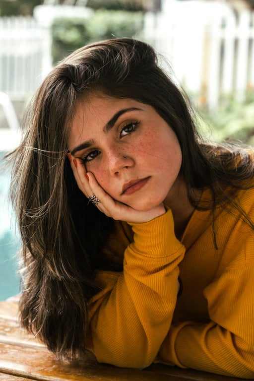 a portrait of a person looking directly at the camera with a warm, confident smile, against a clean and simple background