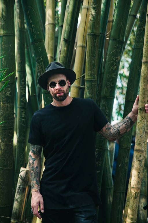 a portrait of a man edited into a classic solid-color one-piece swimsuit, walking along a serene lakeshore