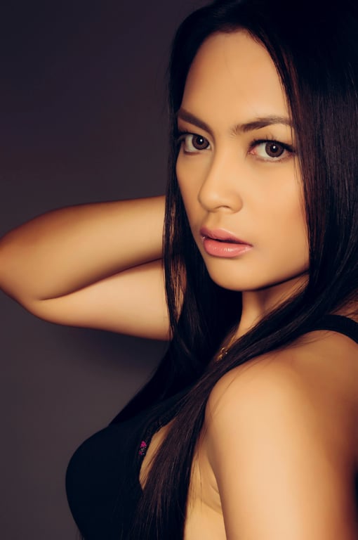 A high-fidelity digital ID photo of a woman, pixel-perfect clarity, natural skin tone without filters, hair away from face, solid light blue background.