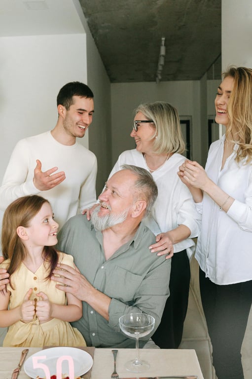 A family name written in a "family tree" doodle font, where each letter is a house containing a small portrait of a family member, connected by branches and roots.