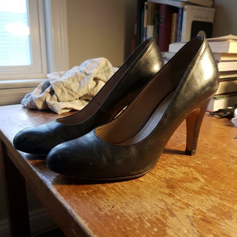 Transform the high heel image into a minimalist runway vanity environment, illuminated by soft diffused natural lighting, rendered with impeccable sharpness and an ethereal glow.