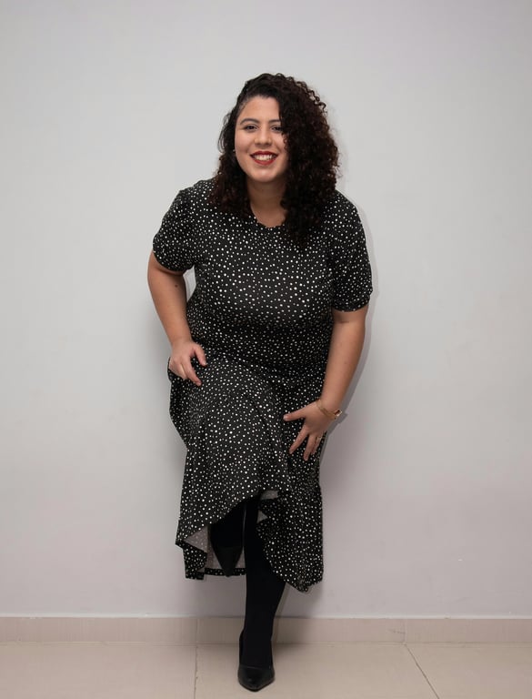 add suit to photo online free – before pic: woman with curly hair in black dress against plain wall