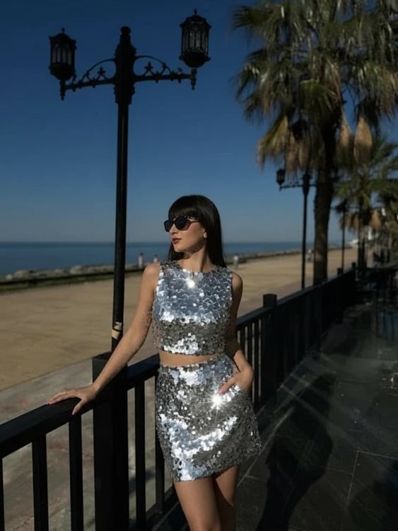 Holiday party outfit after image - person wearing a metallic skirt duo with festive lighting