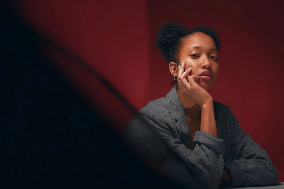 AI green screen remover after photo - woman sitting with dress isolated on dark red background