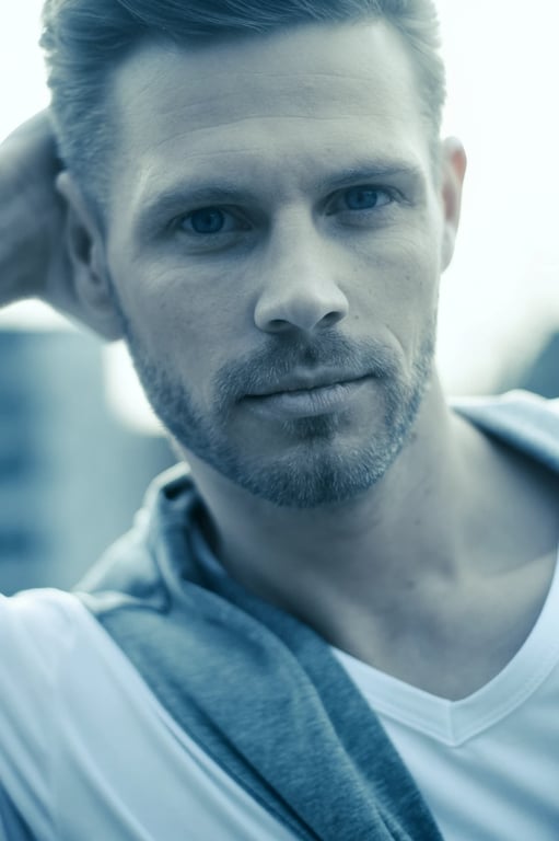 A portrait of a man with an icy blue filter, enhanced cool tones in shadows, crisp white highlights, sharp facial details, modern minimalist style.
