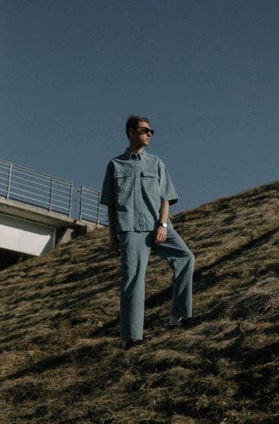 a portrait of a person illustrated in a Demon Slayer–style anime aesthetic, emphasizing movement, fabric flow, and high-contrast shading