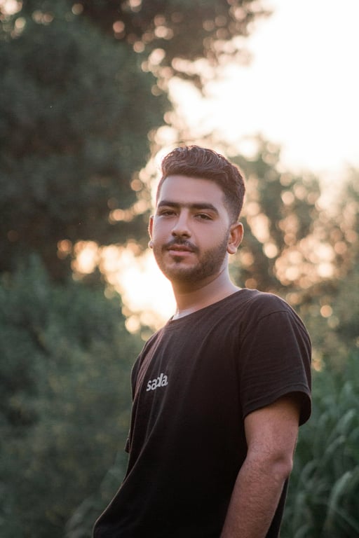 a portrait of a man edited in a Korean wavy perm hairstyle style, so that the top hair has large loose waves forming visible curls typical of Korean men perm looks, while the sides and back are short and straight, with curl texture appearing only on the top section, and unchanged face and original lighting