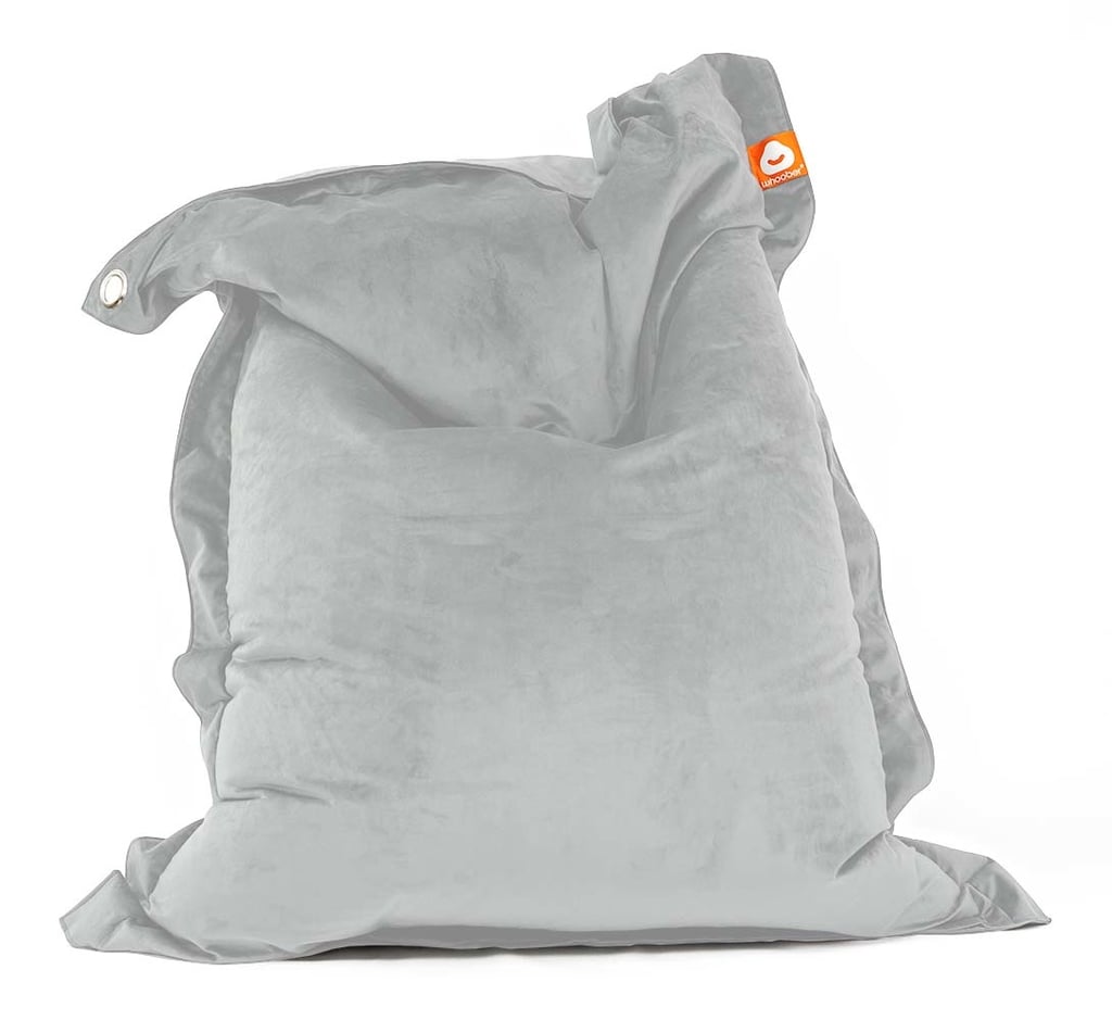 Een grote, lichtgrijze rechthoekige zitzak met zachte stof en een oranje Whoober label staat rechtop. Hij oogt zacht en uitnodigend en suggereert veel zitcomfort.