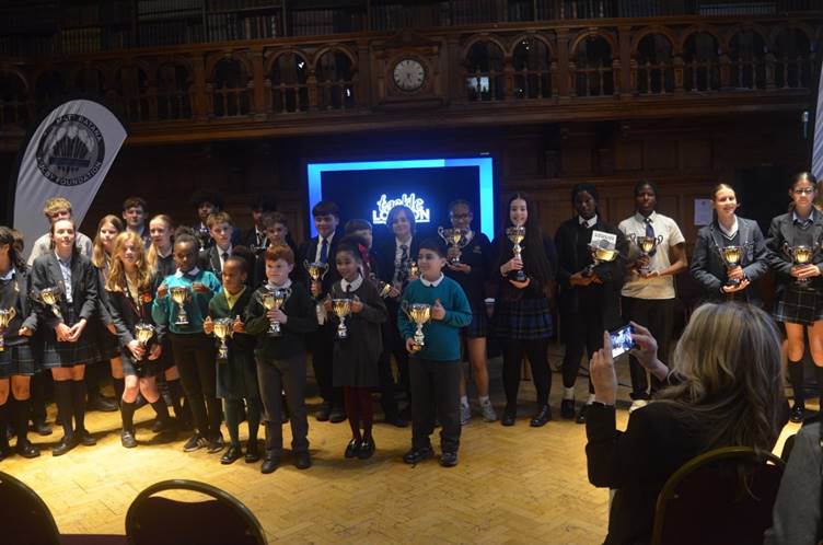 Young people gather holding trophies at the MRRF Awards Ceremony