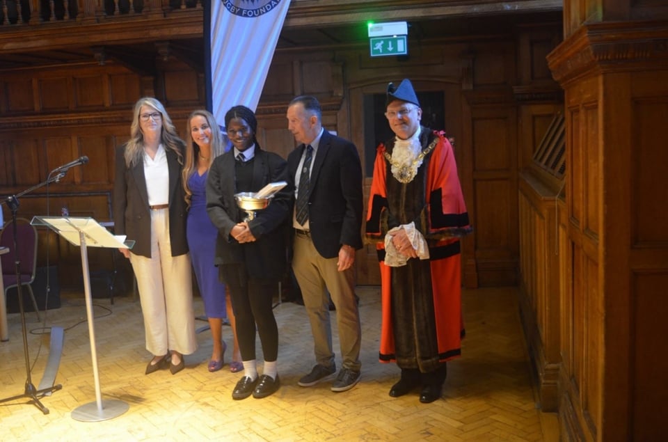 Young people gather holding trophies at the MRRF Awards Ceremony
