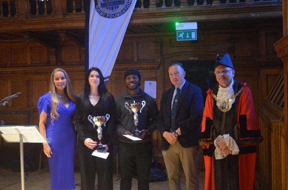 Young people gather holding trophies at the MRRF Awards Ceremony