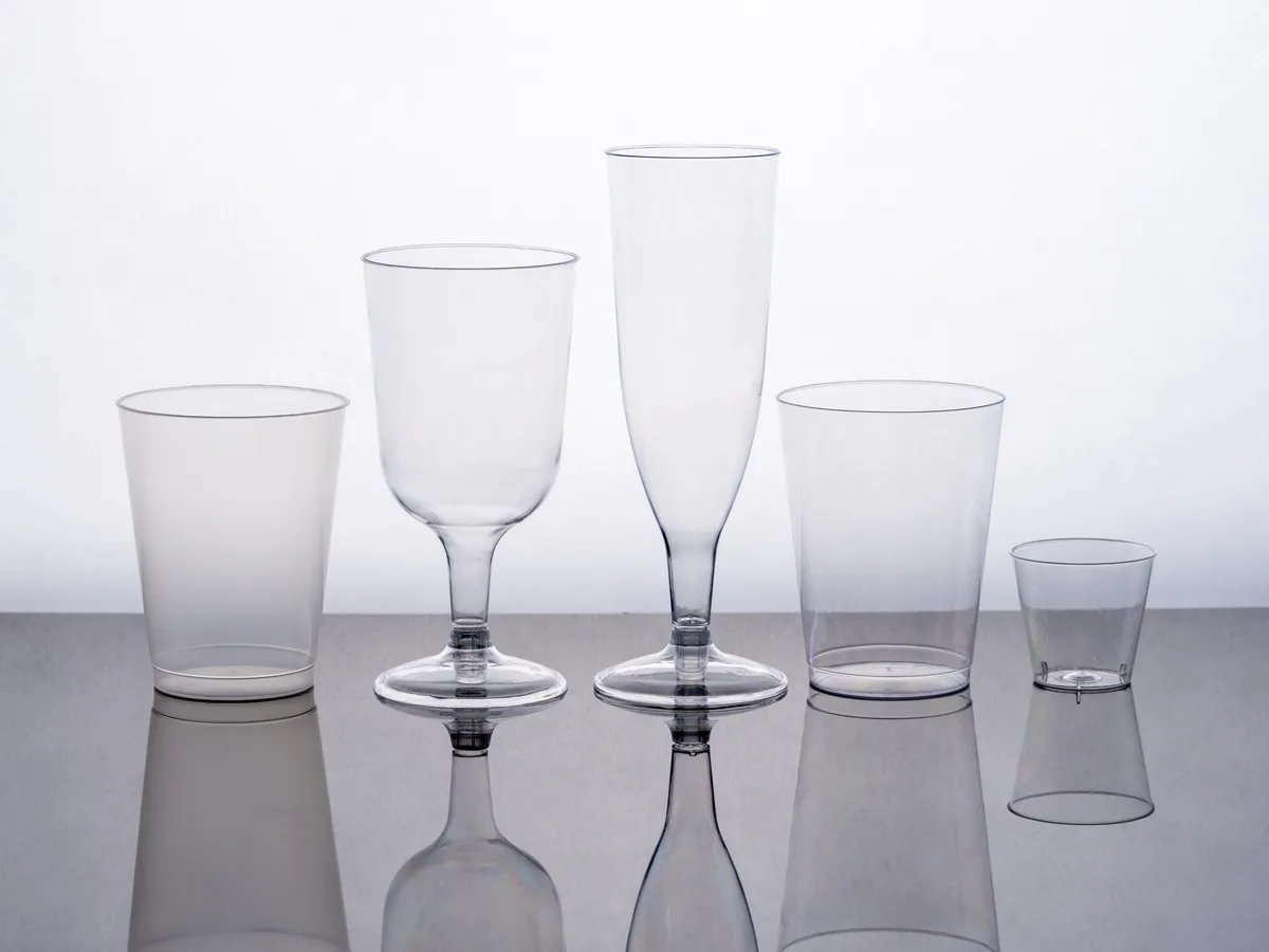 Clear plastic cups and stemware shown in multiple service formats