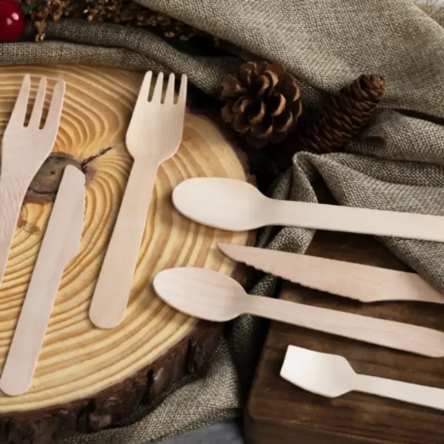 Birchwood cutlery set arranged on a wood slice and natural linen