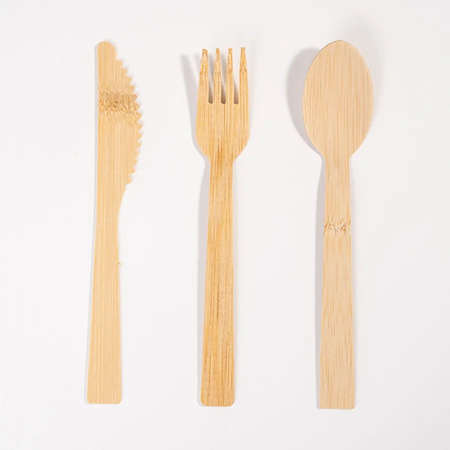 Bamboo knife, fork, and spoon shown together on a white background