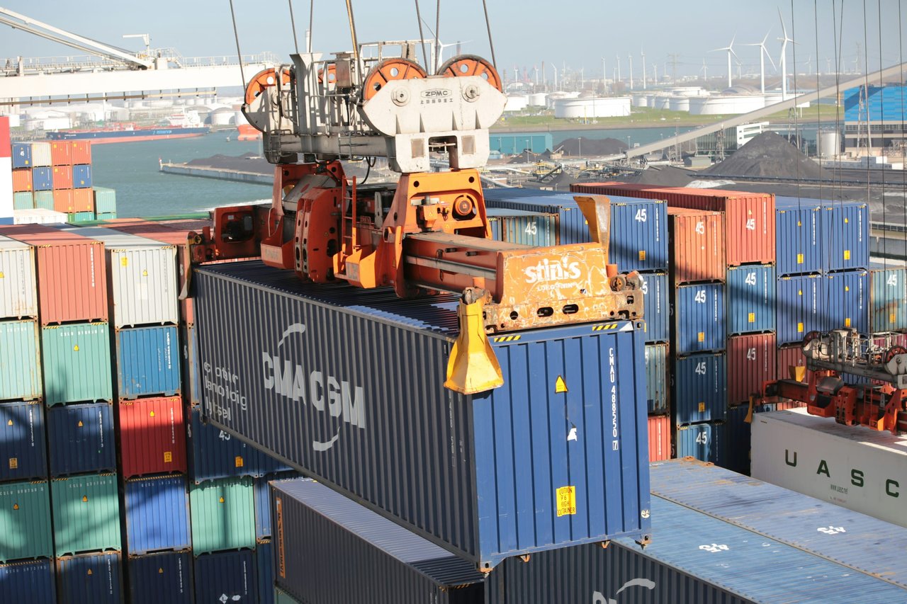 Crane unloading a shipping container onto a truck at a port