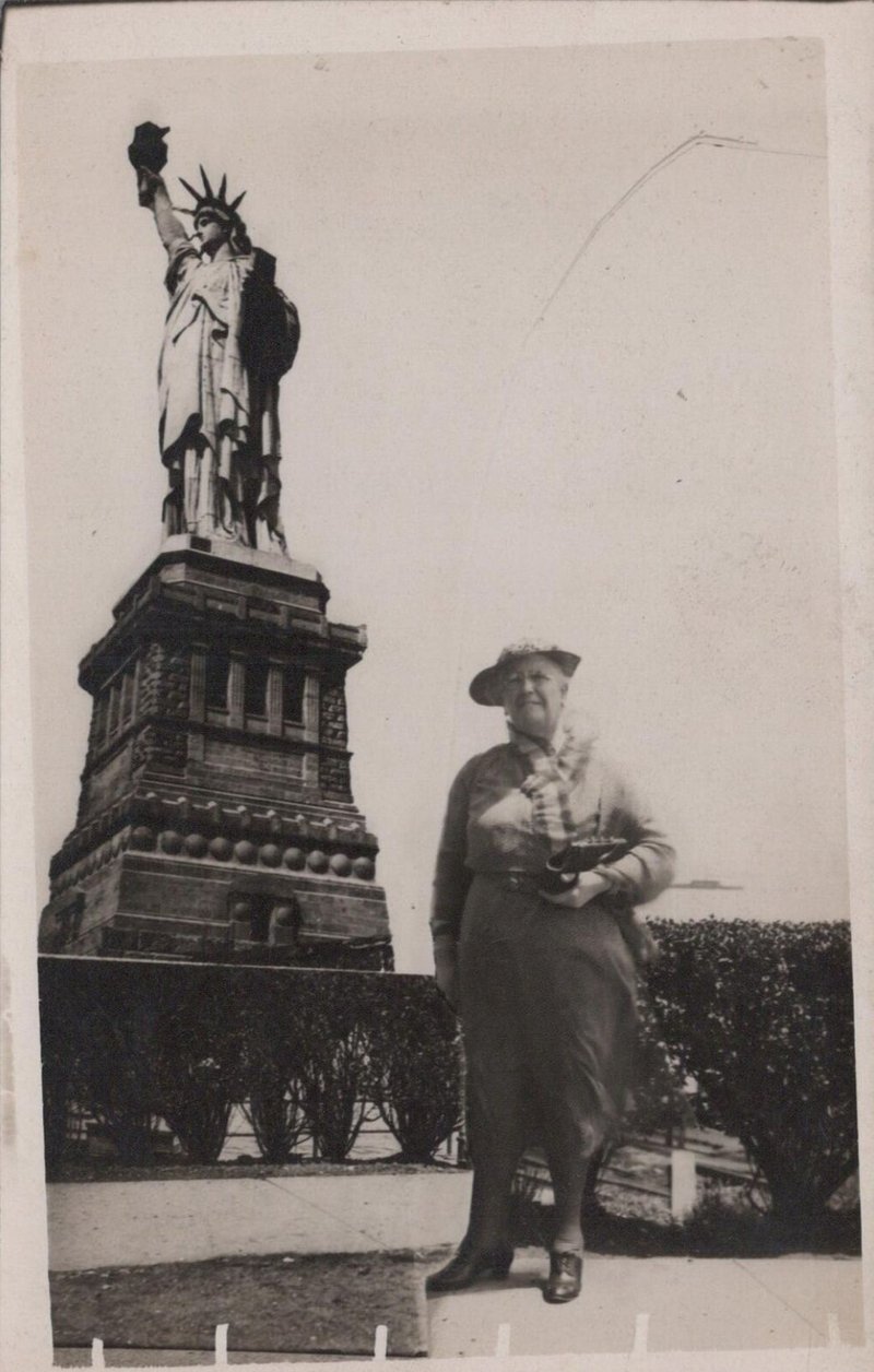 Lady in front of the Statue of Liberty RPPC