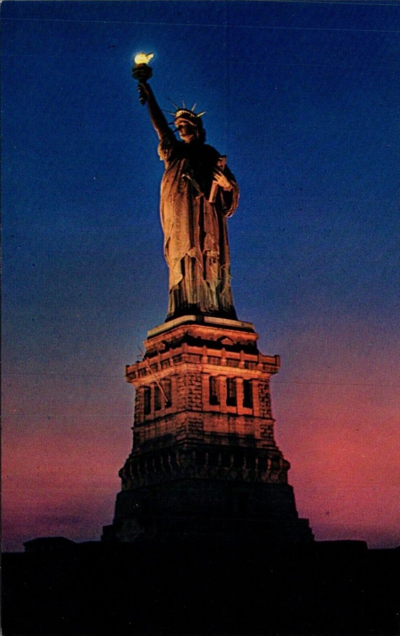 Statue of Liberty at night with glowing torch