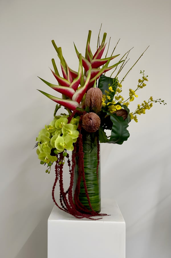 Tropical flowers in a tall glass vase