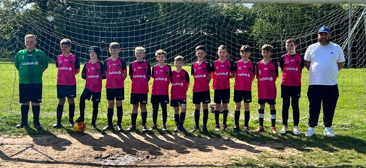 Team Photo of Tendring District FC standing in front of Goal