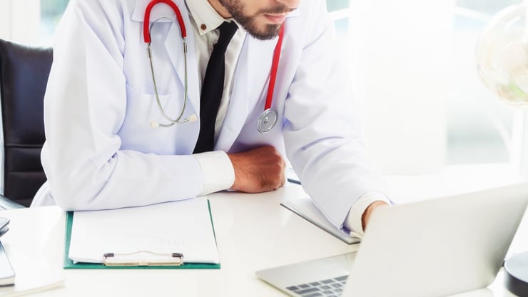 Doctor sitting at a desk with laptop