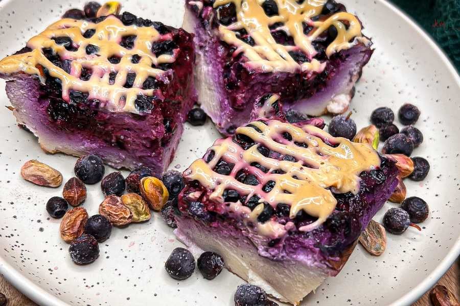 Sernik jagodowy z kremem z białej czekolady i pistacji.