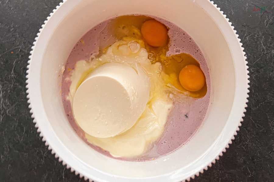 Miska ze składnikami na fit sernik - widać jajka, jogurt, serek.