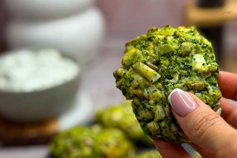 Nuggets jajeczno-brokułowy trzymany w dłoni na tle nuggetsów i sosu