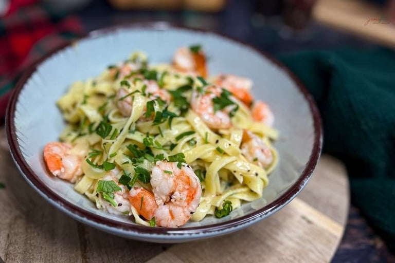 Kremowy makaron z krewetkami na talerzu