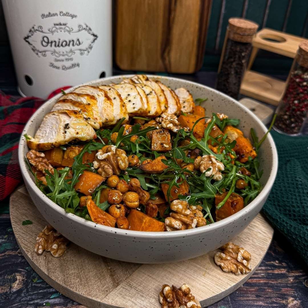 Sałatka znajdująca się w białej misce na drewnianej podkładce